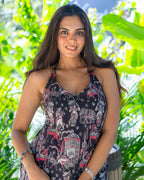 Woman wearing a patterned dress standing in front of green foliage