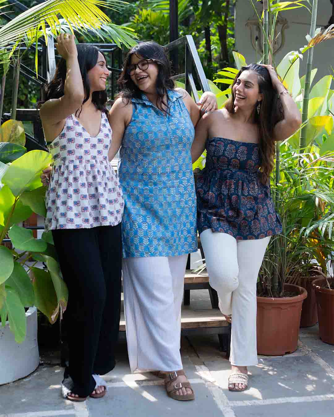Three women standing together in a garden setting