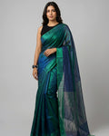 Woman wearing a green and blue saree on a gray background