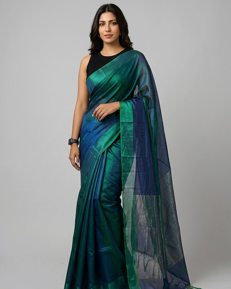 Woman wearing a green and blue saree on a gray background