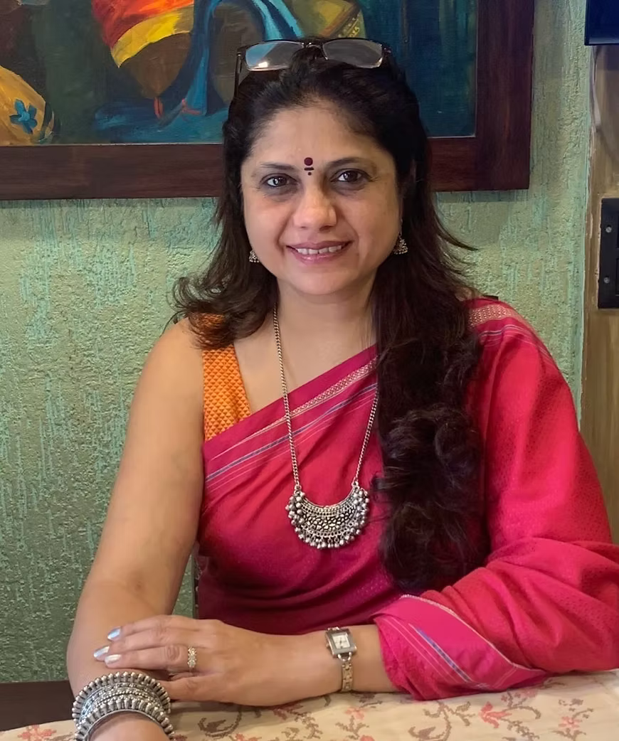 Woman in a red saree with a colorful painting in the background